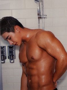 a shirtless man is standing in the shower