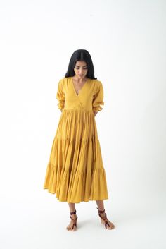 Experience freedom in our loose, tiered boho dress made from 100% organic cotton.  The open V-neck combined with the tiered skirt makes it perfect for beach strolls and summer dinners.  Features two inseam pockets and customizable colour options.  Length: 48 inches.  Quality: 60's Organic Cotton.  Care: Hand wash with light detergent or dry clean.  Ships within 3-5 business days. For quicker delivery please send us a message. Additional Information: Colour: Jaisalmer Mustard (Customizable to you Beach Tiered Cotton Dress With Ruffle Hem, Cotton Tiered Dress With Ruffle Hem For Beach, Beach Cotton Tiered Dress, Beach Tiered Cotton Dress, Spring Cotton Tiered Maxi Dress, Cotton Tiered Beach Dress, Bohemian Cotton Tiered Maxi Dress, Cotton Tiered Dress For The Beach, Bohemian Cotton Maxi Dress With Tiered Design