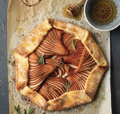 an apple tart pie with rosemary garnish on top