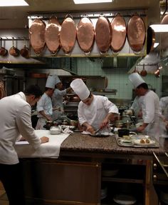 several chefs are in the kitchen preparing food