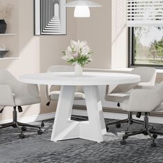 a white round table with four chairs around it and a vase on the end, in front of a window