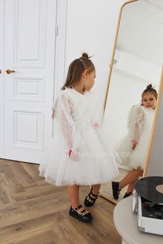 Introducing our delightful tulle dress for girls! With a skirt that falls just below the knee, adorned with a tulle ruffle, this dress exudes charm and elegance. The airy tulle long sleeves add a touch of whimsy to the ensemble, making it simply enchanting. Order your dream dress now by submitting a request on the website or contacting our professionals at the provided phone number. Our consultants will be happy to help you choose the perfect size and color scheme for your little princess. All our dresses are handmade and tailored exclusively after your order, so we can work together to choose the organza print for the dress or make any adjustments you desire. Let your celebration be filled with magic and memories with the wonderful children's festive dresses from Manashakids! The accessor Princess Style Tulle Tutu Dress For First Communion, First Communion Tulle Dress With Ruffles, First Communion Princess Dress With Ruffles, Organza Tutu Dress With Tulle Skirt For First Communion, Princess Style Tutu Dress For First Communion, Ruffled Tutu Dress For First Communion, Princess Style Organza Tutu Dress For Baptism, Pink Tulle Tutu Dress For First Communion, White Princess Tutu Dress In Organza