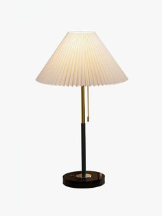 a lamp that is on top of a wooden base and has a white shade over it