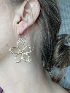 These beautiful wire flower earrings are the perfect way to add a touch of nature to your look. They are made from hand-bent wire and are sure to turn heads. The flowers are made of gold-plated wire, and they will match any outfit. They are also lightweight and comfortable to wear, so you can wear them all day long. These earrings are the perfect gift for any occasion, and they are sure to be a cherished addition to your jewelry collection. Features: Hand-bent wire flowers Variety of colors and Handmade Flower Drop Earrings In Gold, Delicate Gold Flower-shaped Hoop Earrings, Handmade Gold Flower Earrings For Spring, Handmade Flower Shaped Gold Jewelry, Gold Jewelry With Handmade Flowers, Gold Flower Earrings With Ear Wire, Gold Flower Earrings With Handmade Details, Gold Flower Earrings With Handmade Flowers, Spring Gold Jewelry With Handmade Flowers