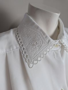 ⭐Description⭐ I'm all about classic blouses with fun details and this blouse definitely delivers.  Cute embroidery details on the collar. Pleated and the neckline with short sleeves ⭐Condition ⭐ Excellent condition. ⭐Measurements taken flat⭐ Pit to pit - 23" shoulder to shoulder - 19" length - 27" ⭐THANK YOU⭐ I am one woman on a mission to find beauty in discarded treasures and make sure they go to good homes where they will be used for years to come! ⭐NOTE⭐ Some of my pieces may show minor wear Classic Embroidered Summer Shirt, Fitted Embroidered Top With Collared Neckline, Vintage Lace Collar Button-up Top, Classic Embroidered Short Sleeve Shirt, Embroidered Summer Blouse With Collared Neckline, Classic Embroidered Short Sleeve Top, Vintage Summer Blouse With Lace Collar, Vintage Lace Collar Blouse For Summer, White Collared Tops With Embellished Collar