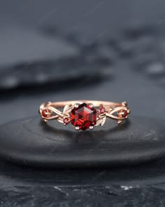 a red stone ring sitting on top of a rock