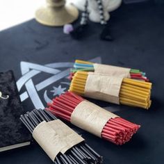 several different colored matches are on the table next to a book and some other items