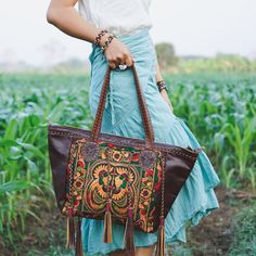 "This shoulder bag is the perfect addition to enhance your offerings. It features a tribal hmong pattern, cotton lining, adorned with black leather tassel as decoration. This shoulder bag will highlight your fabulous offerings. We buy materials from Hmong market and we design and sew by hand. Some of the bags we modify to improve the product. The Hmong tribes live in the North of Thailand and have origins from the Tibetan area of China. You may not receive the exact bag picture here, As the fabr Traditional Satchel For Travel, Bohemian Shoulder Bag With Removable Pouch For Travel, Bohemian Top Handle Satchel For Everyday Use, Bohemian Rectangular Bag For Market, Bohemian Rectangular Bag For Shopping, Embroidered Tote Bag For Travel, Bohemian Bag With Removable Pouch And Double Handle, Artisan Shoulder Bag For Travel, Embroidered Leather Travel Bags