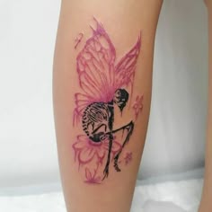 a woman's leg with a skeleton and pink flower tattoo on the side of it