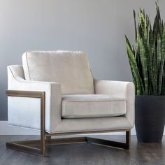 a white chair sitting next to a potted plant