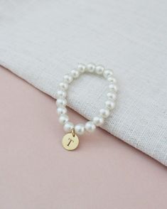 All time classic pearls bracelet with added initial to complete your look. Choose from silver, rose gold, or gold initials to match with your personality and give a modern touch on a traditional style.Great for bride or for birthday gifts, flower girls, brides or or bridesmaids to wear on the wedding day. ** Please put the preferred letter initial on notes upon checkout ** This listing is only for 1 bracelet. Bracelet is measured to approximately 7 - 8 inches, however, it can stretch to match wr Classic White Jewelry With Initials, Elegant White Monogram Jewelry, Classic Personalized Adjustable Pearl Bracelet, Personalized Adjustable Classic Pearl Bracelet, Classic Letter Beads Jewelry As Gift, Classic Letter Beads Jewelry Gift, Classic Adjustable Personalized Pearl Bracelet, Minimalist White Jewelry With Monogram, Classic Personalized Pearl Jewelry