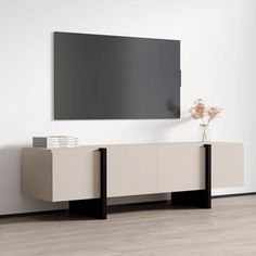 a white and black entertainment center in an empty room with a large flat screen tv mounted on the wall