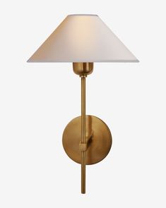 a brass wall light with a white shade on the top and bottom half of it