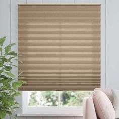 a living room with a couch, chair and window blinds in shades of brown stripes