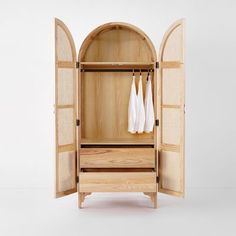 an open wooden cabinet with two white towels hanging on it