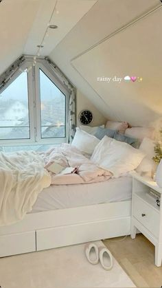 there is a bed in the attic with white sheets and pillows on top of it