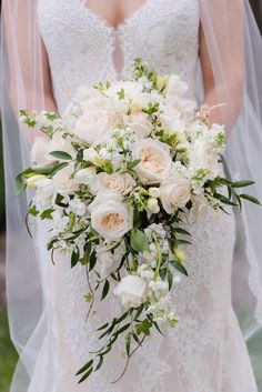 a bridal holding a bouquet of white flowers