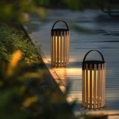 two lanterns sitting on top of a wooden walkway