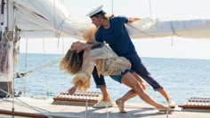 a man and woman are kissing on the deck of a sailboat