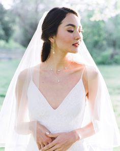 A bride wears Teardrop Pearl Long Earrings, paired with a pearl station necklace. Minimalist Pearl Drop Teardrop Earrings For Wedding, Minimalist Teardrop Pearl Bridal Earrings, Minimalist Teardrop Pearl Earrings For Wedding, Minimalist Pearl Pendant Earrings For Wedding, Delicate Teardrop Pearl Pendant Earrings, Dainty Teardrop Pearl Pendant Earrings, Minimalist Teardrop Dangle Earrings For Wedding, Minimalist Dangle Teardrop Earrings For Wedding, Delicate Teardrop Pearl Drop Bridal Earrings