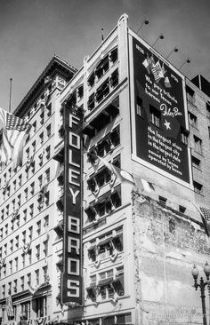 an old black and white photo of a building with flags on the side of it