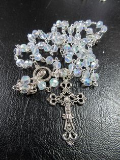 "This Catholic rosary is made of clear Aurora Borealis crystals. It is a complete 5 decades and a good gift for First Communion or a Baptism. The body is 26\" around and the cross drop is 5 inches. The rosary will be slipped into a velvet bag and shipped in a bubble mailer." Silver Beaded Jewelry For Baptism, Silver Crystals With Beads For Gifts, Silver Jewelry With 8mm Beads For Baptism, Spiritual Silver Rosary As Gift, Silver Beaded Rosary With Spiritual Style, Silver Faceted Beads Crystals As Gift, Silver Jewelry With 8mm Beads For First Communion, Spiritual Silver Crystal, Silver Crystals With 8mm Beads For Gifts