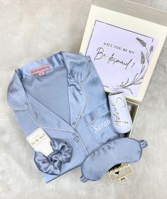 the blue pajamas are next to an open box with a note on it and a pair of slippers