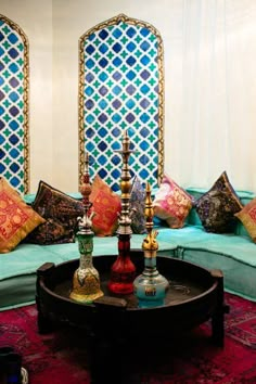 a living room filled with lots of furniture and colorful pillows on top of a coffee table