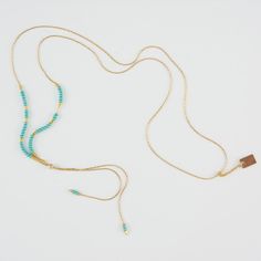 Delicate adjustable gold necklace with turquoise and gold beads and gold rectangle drop pendant. Adjustable Turquoise Elegant Lariat Necklace, Elegant Adjustable Beaded Necklaces, Elegant Adjustable Beaded Necklace, Adjustable Double Strand Clavicle Chain Necklace, Adjustable Double Strand Beaded Chain Necklace, Elegant Turquoise Lariat Necklace With Adjustable Chain, Elegant Turquoise Beaded Lariat Necklace, Turquoise Beaded Chain Lariat Necklace, Turquoise Lariat Necklace With Beaded Chain