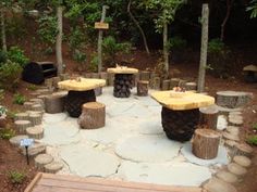 a wooden bench sitting in the middle of a forest filled with trees and rocks on top of it