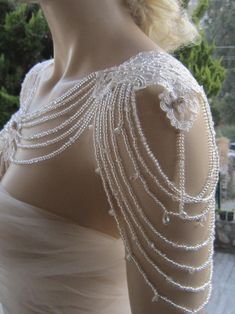 the back of a woman's dress with pearls on it