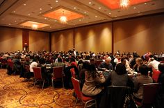 a large room filled with people sitting at tables