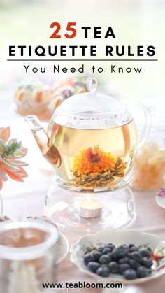 a tea pot filled with blueberries and flowers on top of a table