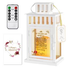 a small white lantern with a poem on it and a remote control next to it