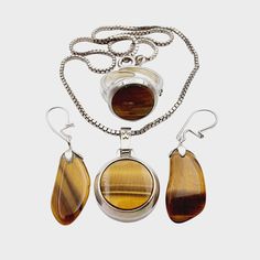 NO. 1693(1) Three vintage pieces of silver jewelry charming Tiger's Eye stone: Necklace: Hallmark: 835 Size: approx. 38 cm - Pendant: approx. 29 x 18 mm (eyelet included) Weight: 11.82 g Earrings: Hallmark: - / at least 800 silver tested Weight: 2.68 g Size: approx. 26 x 11 mm Ring: Hallmark: 835 Size: Ring: Ø approx. 55 (adjustable) - ring top head: approx. 16 x 16 mm Weight: 5.81 g Note: We sell antique/vintage pieces of jewelry, so there might be some signs of wear due to their age. Please lo Classic Silver Jewelry With Stones, Round Stones Costume Jewelry, Nickel-free Vintage Amber Jewelry, Vintage Amber Jewelry With Polished Finish, Nickel-free Amber Vintage Jewelry, Vintage Nickel-free Amber Jewelry, Vintage Amber Nickel-free Jewelry, White Gold Pendant Jewelry With Stones, White Gold Sterling Silver Jewelry With Stones