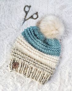 a white and blue knitted hat with a pair of scissors