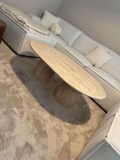 a living room with a couch, coffee table and sectional sofa in the corner on carpeted flooring