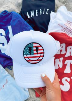 "The perfect hat for summer! Now you can purchase my most popular American Flag Smiley Patch already attached to a hat. ✳Size: one size fits most, with snaps to make it larger or smaller! ✳Color: White ✳Kind: Trucker hat ✳INCLUDES ONE HAT WITH PATCH ON IT IMPORTANT Once your order is shipped I am not responsible/liable for the package. The United States Postal Service is responsible for delivery. If there are any problems with the delivery or a missing package, please reach out to me and I will Patched Trucker Hat, Fourth Of July Hats, 4th Of July Hats, Hat With Patch, Hat For Summer, Patriotic Hats, Letter Envelope, Face Patches, Hat Patches