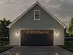 a garage with two lights on the side of it and a driveway in front of it