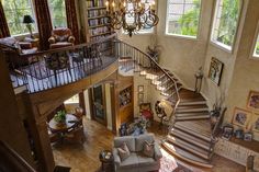 a living room filled with furniture and a spiral staircase leading up to the second floor