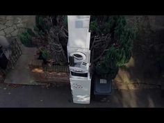 an aerial view of a washing machine in the middle of a driveway next to some trees