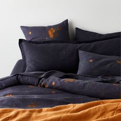 a bed with blue and orange linens on it