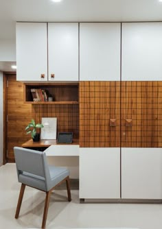 a chair sitting in front of a desk with a laptop on it next to a book shelf