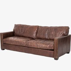 a brown leather couch sitting on top of a white floor