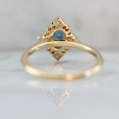 Why I Love It: There are few things in life more perfect than a vintage silhouette paired with an absolutely stunning oval cut sapphire. The color of this stone is a teal-blue with a hint of cerulean-blue -- it's neither too light or too dark. Accompanied by a generous smattering of white princess and round brilliant cut diamonds to frame the center stone, this ring is set in a luscious 14k Yellow Gold and is stackable. The Details: 14k Yellow Gold .53 Carat Teal Blue Oval-Cut Natural high quali Oval Sapphire Ring With Rose Cut Diamonds For Promise, Blue Rose Cut Diamond Birthstone Ring For Wedding, Blue Birthstone Ring With Rose Cut Diamonds For Wedding, Oval Birthstone Ring With Rose Cut Diamonds For Promise, Promise Oval Birthstone Ring With Rose Cut Diamonds, Heirloom Marquise Birthstone Ring For Anniversary, Gold Marquise Sapphire Wedding Ring, Oval Rose Cut Diamond Cluster Ring For Wedding, Oval Rose Cut Diamond Birthstone Ring For Wedding