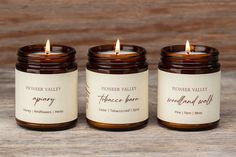 three candles sitting on top of a wooden table next to each other with the words frontier valley candle company written on them