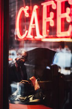 a man sitting at a table in front of a cafe