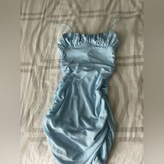 a baby sleeping bag on top of a bed covered in blue sheets and linens