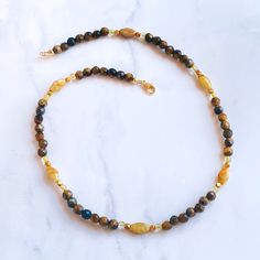 17.5" total length clasp and sterling silver with gold vermeil beads. All genuine Tiger eye, rutile gold, and yellow calcite gemstones if you need it sized, feel free to message me Tiger’s Eye is a golden-brown banded variety of quartz that exhibits chatoyancy, or the “cat’s eye effect”–a luminous streak that moves as you rotate the stone. Tiger Eye is a stone often feared and revered for being an all seeing and all knowing eye. It is said to grant the wearer with a keen ability of observation t Gold Labradorite Crystal Necklace With Gemstone Beads, Gold Labradorite Necklace With Gemstone Beads, Gold Beaded Necklace With Labradorite Stones, Gold Crystal Necklaces With Gemstone Beads, Gold Labradorite Gemstone Beaded Necklace, Handmade Gold Labradorite Beaded Necklaces, Gold Single Strand Agate Necklace, Gold Agate Beaded Crystal Necklaces, Gold Beaded Agate Crystal Necklaces