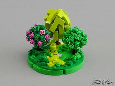 a lego model of a tree surrounded by flowers